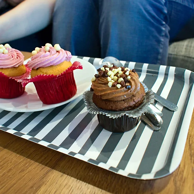 La photo de départ : trois cupcakes sur un plateau rayé, sur une table de cuisine