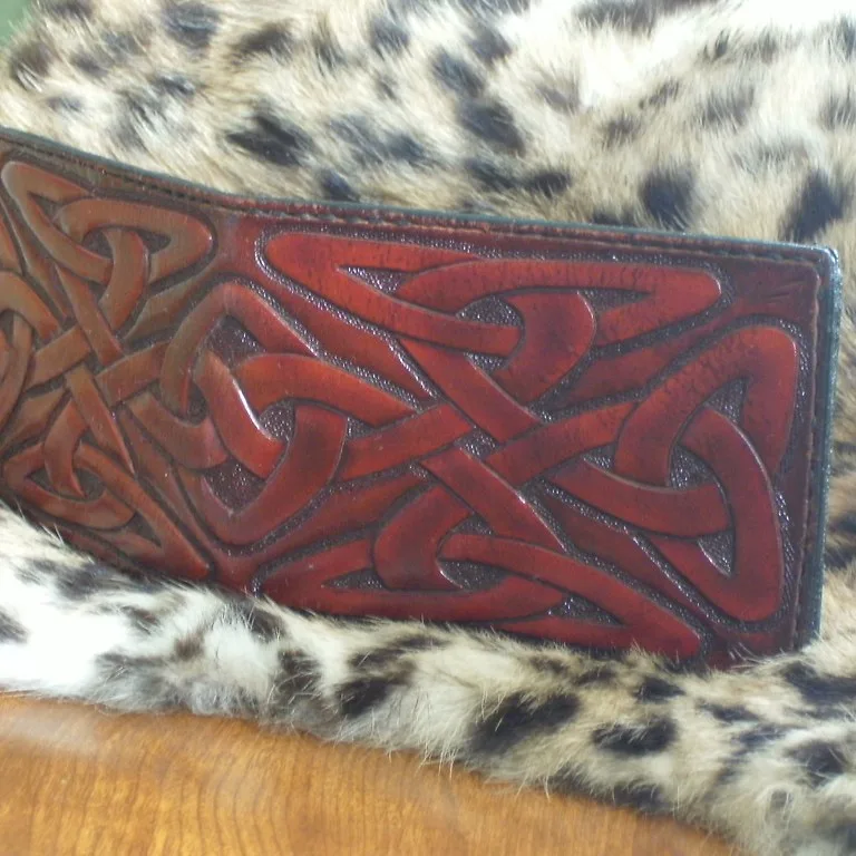 La photo de départ : un portefeuille en cuir repoussé à motif celtique, posé sur une fausse fourrure