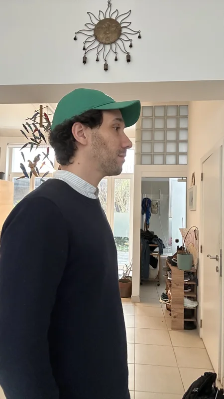 Ma photo de départ&nbsp;: de profil chez moi, pull marine, casquette verte