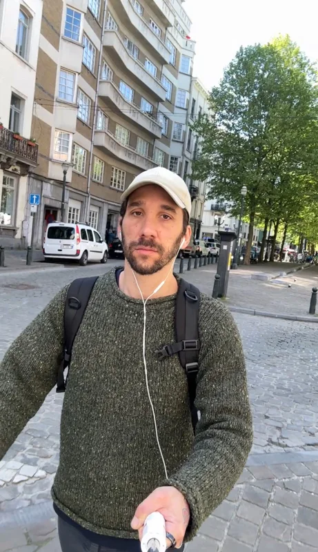 Ma photo de départ&nbsp;: dans la rue, pull vert, sac à dos, casquette claire