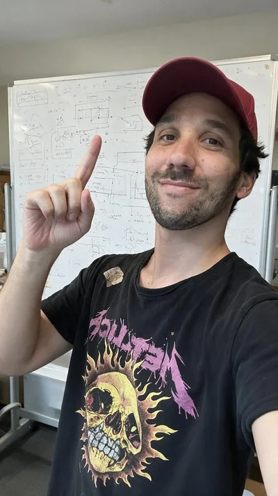 La retouche : le même selfie dans une salle de formation, tableau blanc couvert de schémas, t-shirt imprimé